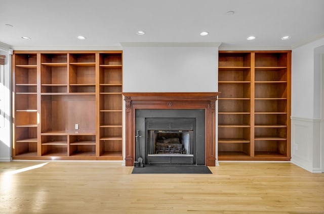 unfurnished living room featuring crown molding and light hardwood / wood-style floors