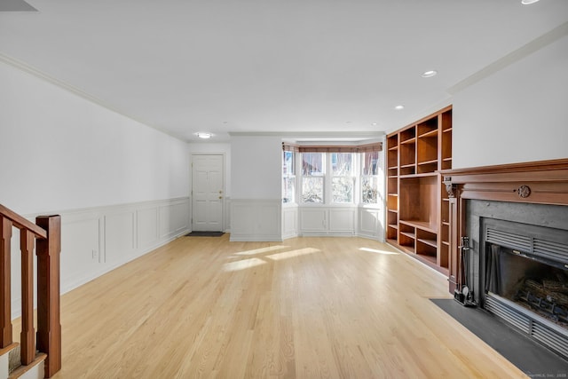 unfurnished living room with built in shelves and light wood-type flooring