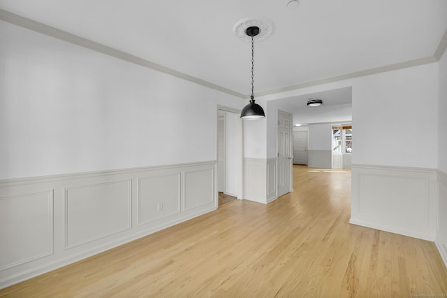 unfurnished dining area with crown molding and light hardwood / wood-style floors