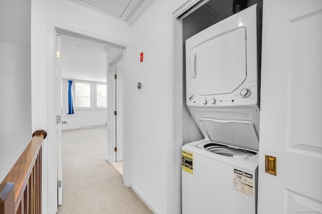 laundry room with crown molding, stacked washing maching and dryer, and light carpet