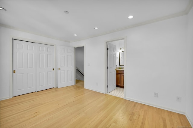 unfurnished bedroom with crown molding, light hardwood / wood-style flooring, a closet, and ensuite bathroom