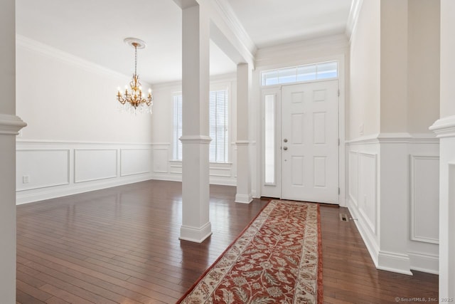 entrance foyer featuring crown molding and ornate columns