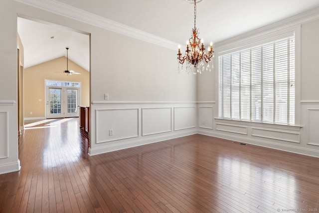 spare room with dark hardwood / wood-style flooring, ceiling fan with notable chandelier, vaulted ceiling, and ornamental molding