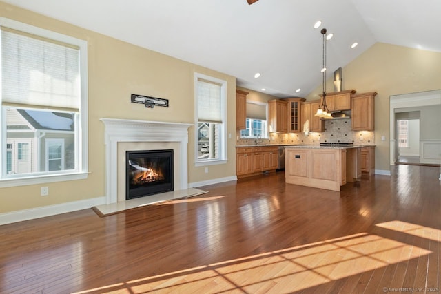 kitchen featuring stainless steel dishwasher, dark hardwood / wood-style floors, a kitchen island, pendant lighting, and backsplash