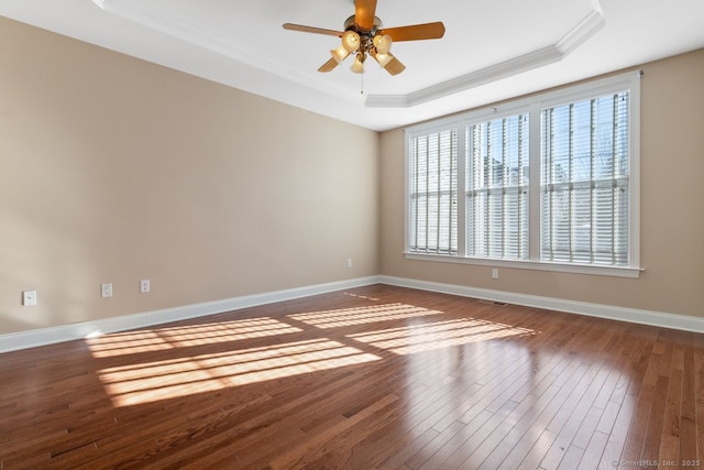 spare room featuring hardwood / wood-style floors, ornamental molding, a raised ceiling, and ceiling fan