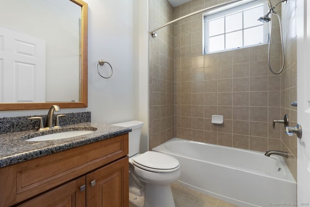 full bathroom featuring vanity, tiled shower / bath combo, tile patterned floors, and toilet