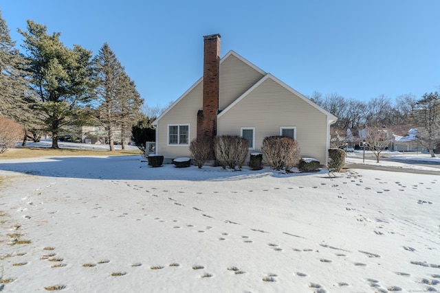 view of snow covered back of property