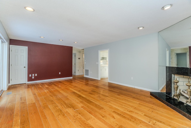 unfurnished living room featuring a fireplace and light hardwood / wood-style flooring