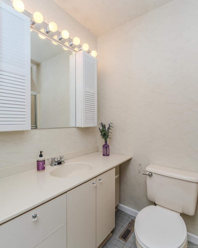 bathroom featuring vanity, tile walls, and toilet