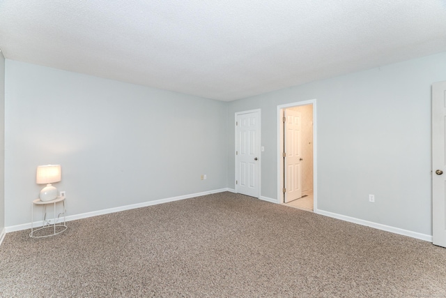 spare room featuring light carpet and a textured ceiling