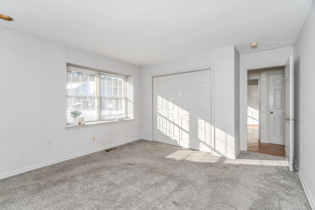 carpeted spare room featuring a textured ceiling