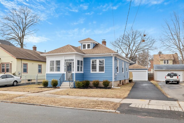 bungalow featuring an outbuilding and a garage