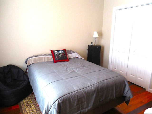 bedroom featuring dark hardwood / wood-style flooring and a closet