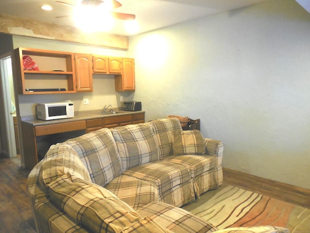 living room featuring ceiling fan, dark hardwood / wood-style floors, and sink