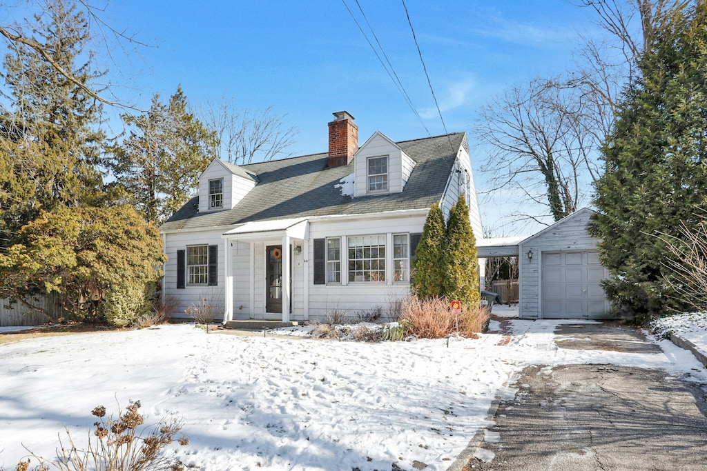 cape cod home with an outbuilding and a garage