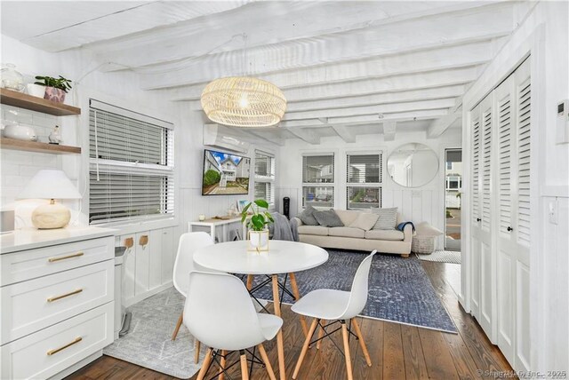 dining room featuring dark wood-type flooring and beam ceiling