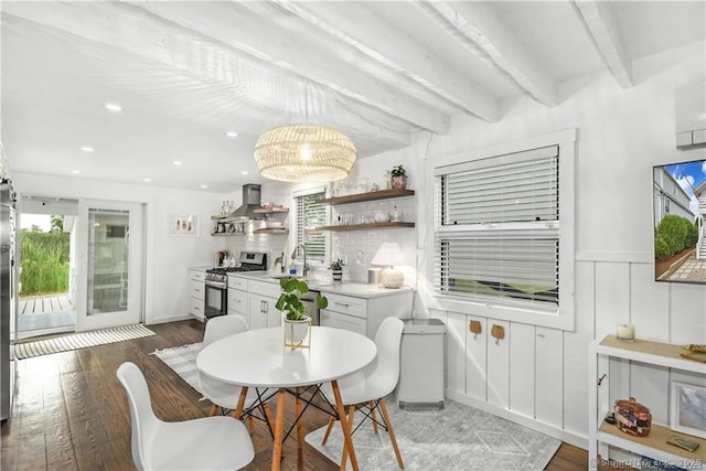 dining space with beamed ceiling, dark hardwood / wood-style floors, and sink