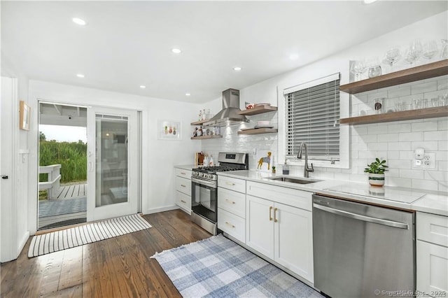 kitchen with sink, island range hood, white cabinets, and appliances with stainless steel finishes