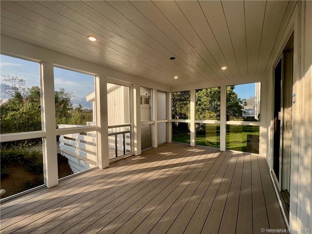 unfurnished sunroom featuring wood ceiling and a wealth of natural light