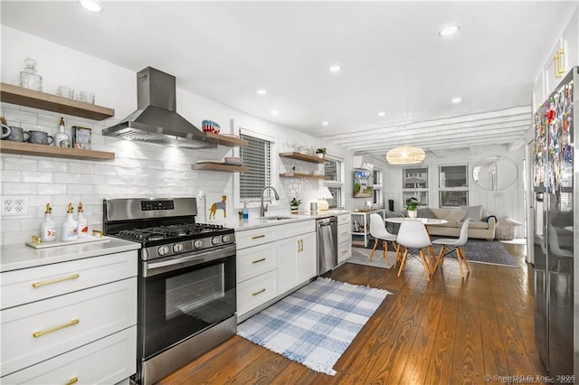 kitchen with dark hardwood / wood-style floors, island range hood, white cabinets, decorative backsplash, and stainless steel appliances