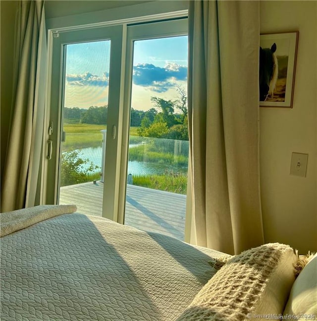 bedroom with a water view and access to outside