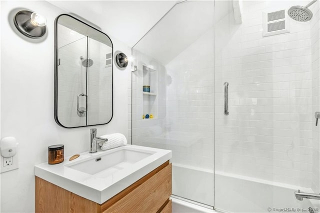 bathroom with vanity and shower / bath combination with glass door