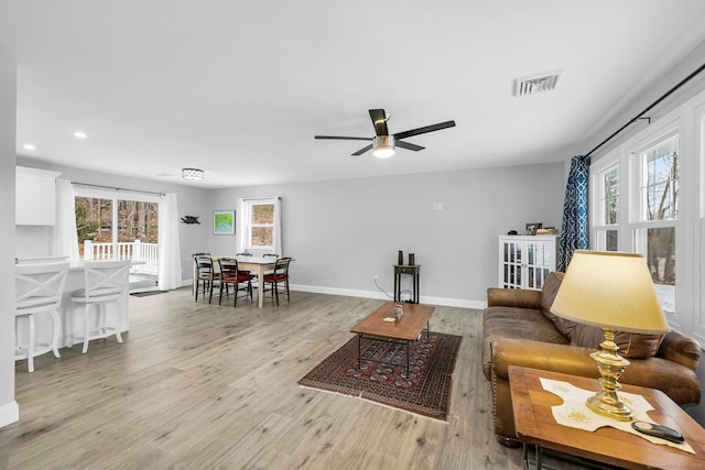 living room with ceiling fan, a healthy amount of sunlight, and light hardwood / wood-style floors