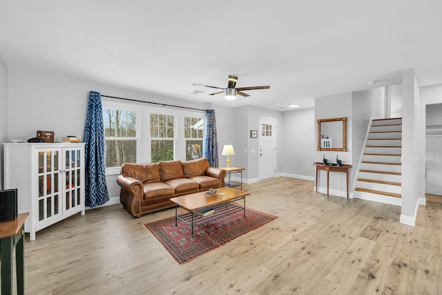 living room featuring light hardwood / wood-style flooring and ceiling fan