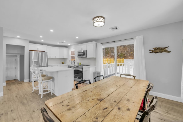 dining area with sink and light hardwood / wood-style flooring