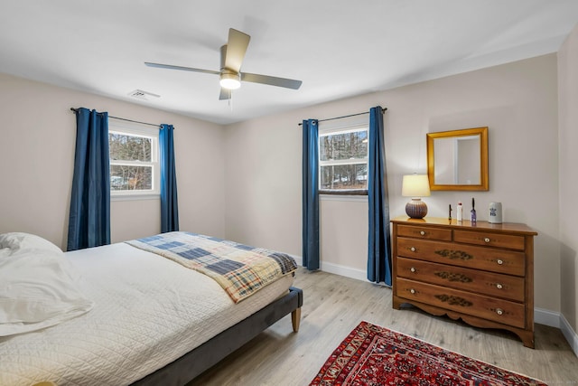 bedroom with multiple windows, ceiling fan, and light hardwood / wood-style flooring