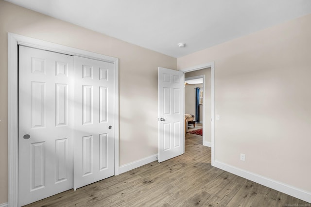 unfurnished bedroom featuring light hardwood / wood-style flooring and a closet