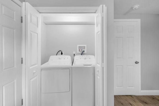 clothes washing area with washer and dryer and light hardwood / wood-style flooring