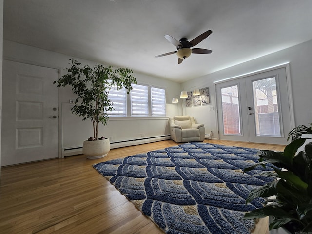 bedroom with a baseboard radiator, hardwood / wood-style floors, ceiling fan, and french doors