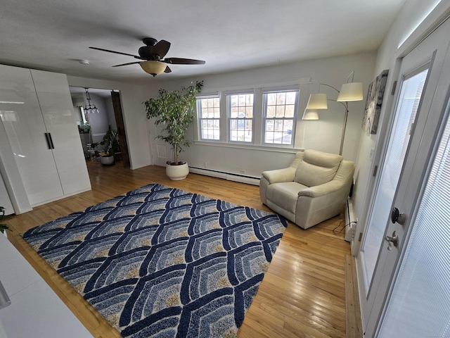 sitting room featuring a baseboard heating unit and hardwood / wood-style floors