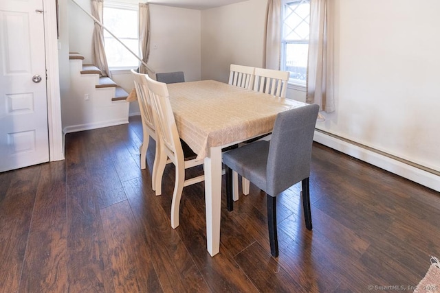 dining area with a baseboard heating unit and dark hardwood / wood-style floors