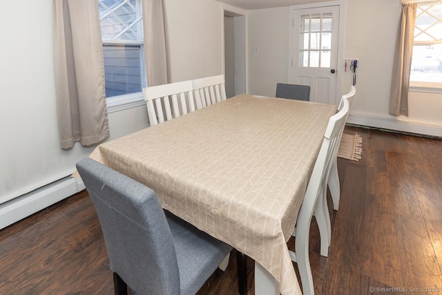 dining area featuring a baseboard heating unit and dark wood-type flooring