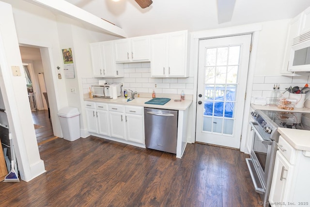 kitchen with dark wood-type flooring, ceiling fan, appliances with stainless steel finishes, backsplash, and white cabinets