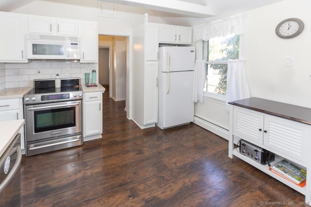 kitchen with appliances with stainless steel finishes, a baseboard heating unit, white cabinets, and decorative backsplash