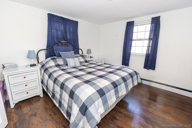 bedroom featuring dark hardwood / wood-style flooring and a baseboard heating unit