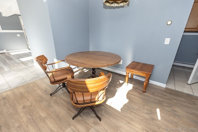 dining area featuring light hardwood / wood-style flooring and a baseboard heating unit