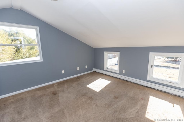 additional living space with a baseboard heating unit, carpet floors, and vaulted ceiling