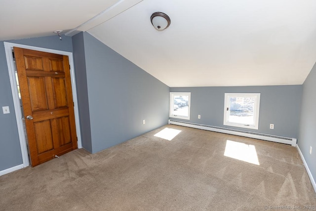 additional living space featuring a baseboard radiator, lofted ceiling, and light carpet