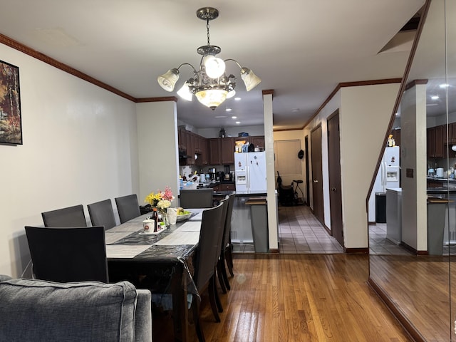 dining space with an inviting chandelier, crown molding, and hardwood / wood-style floors