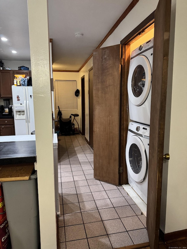 laundry area featuring stacked washer and dryer and ornamental molding