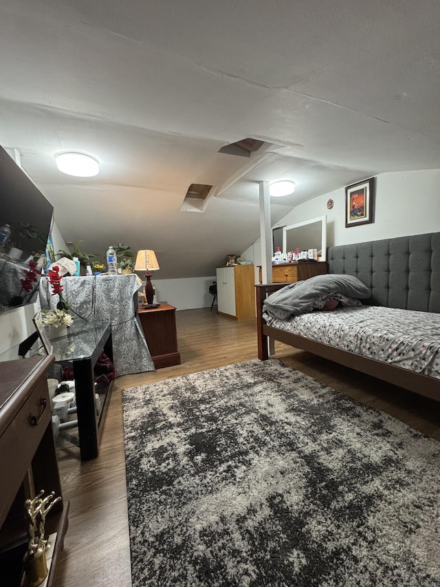 bedroom featuring wood-type flooring and vaulted ceiling