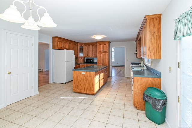 kitchen featuring pendant lighting, sink, a center island, and white refrigerator