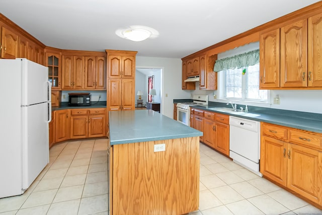 kitchen featuring light tile patterned flooring, white appliances, sink, and a kitchen island