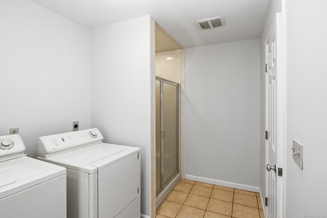 laundry room with independent washer and dryer and light tile patterned floors