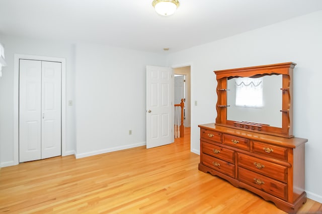 bedroom with light hardwood / wood-style floors and a closet