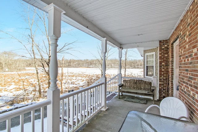 view of snow covered back of property